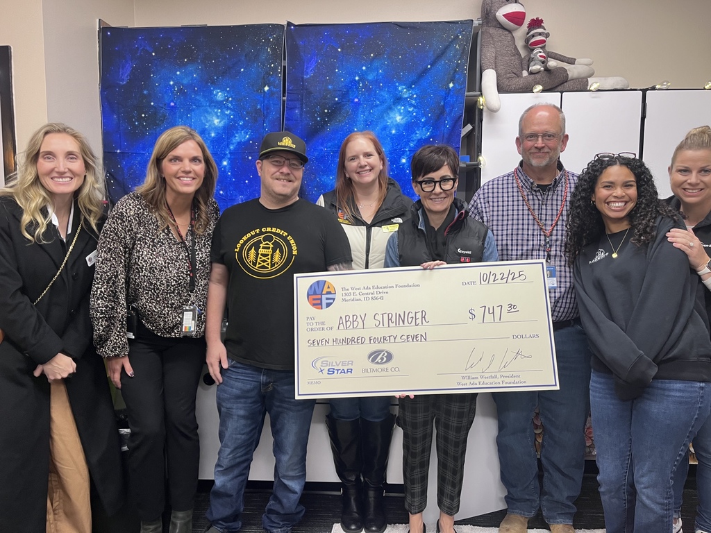 Ms. Abby holding a check as a grant winner. 