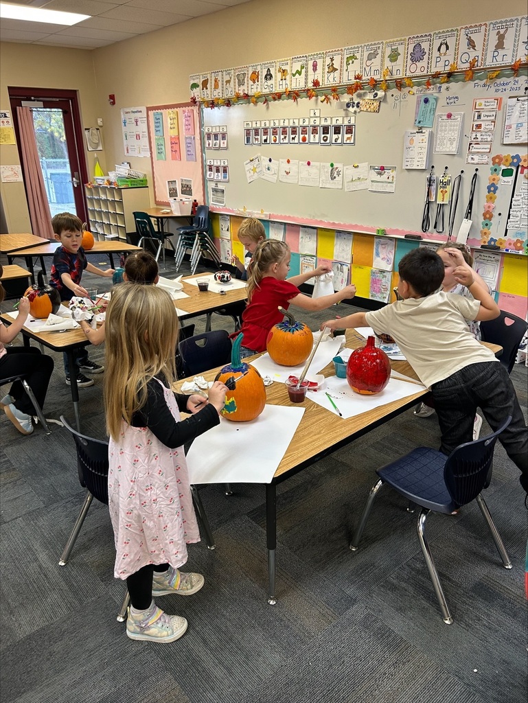 students painting pumpkins