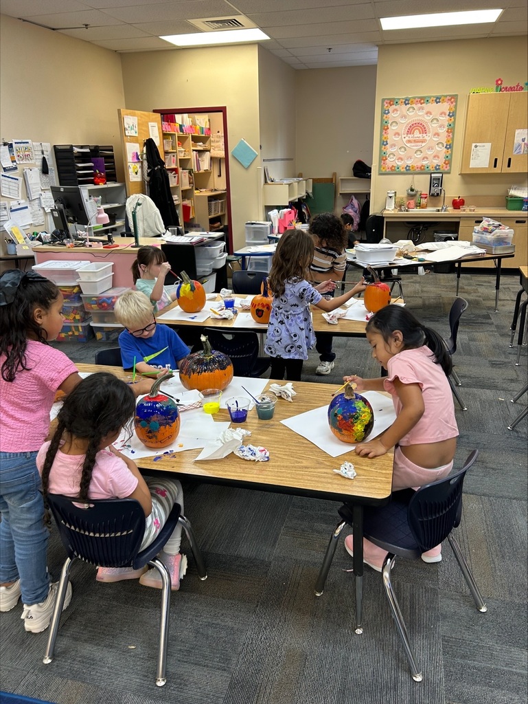students painting pumpkins
