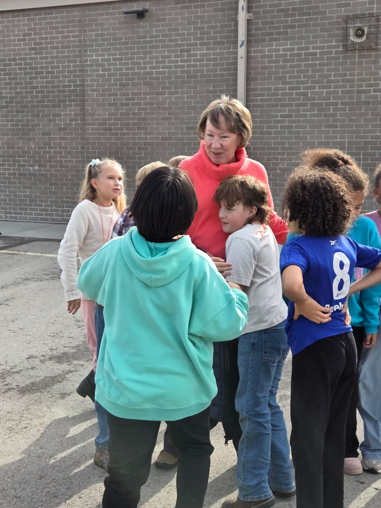 An image of students hugging former principal Mrs. Hart
