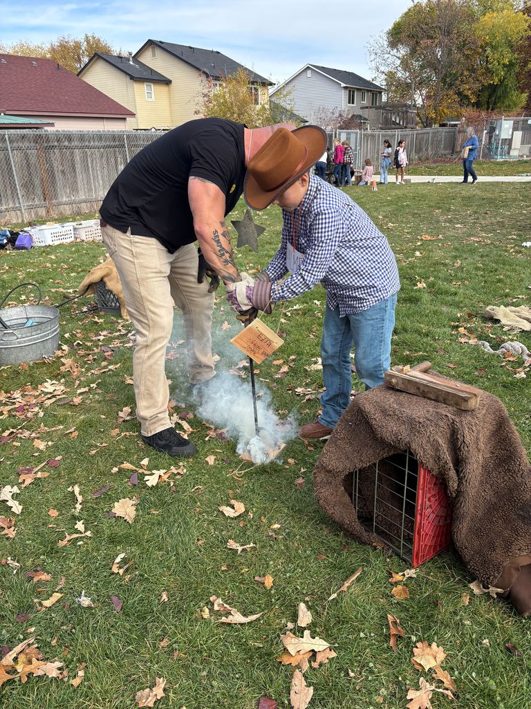 An image of a student and volunteer making fire