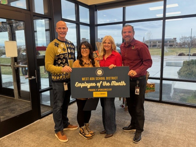 Cynthia Anderson and district representatives present the Employee of the Month