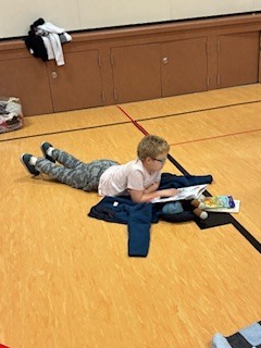 student reading on gym floor