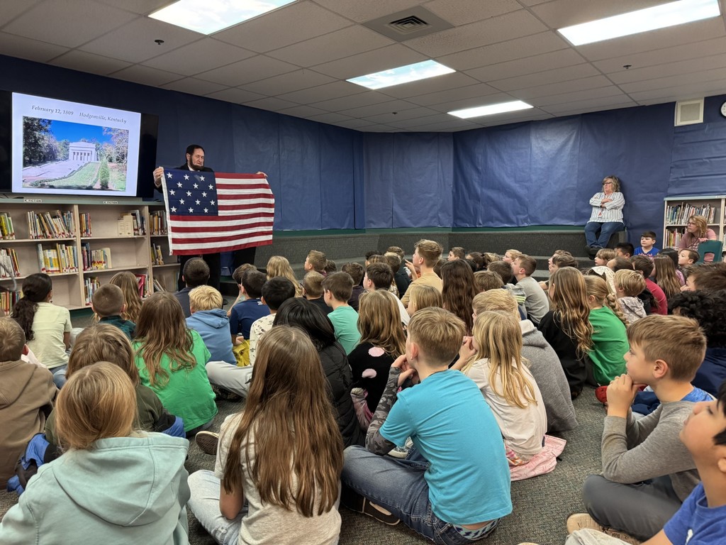 Abe Lincoln shows 3rd graders the US flag at the time of the civil war