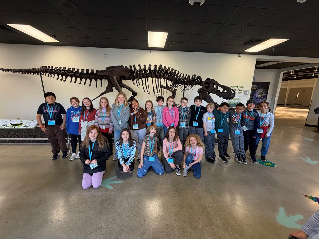 kids in front of a dinosaur skeleton