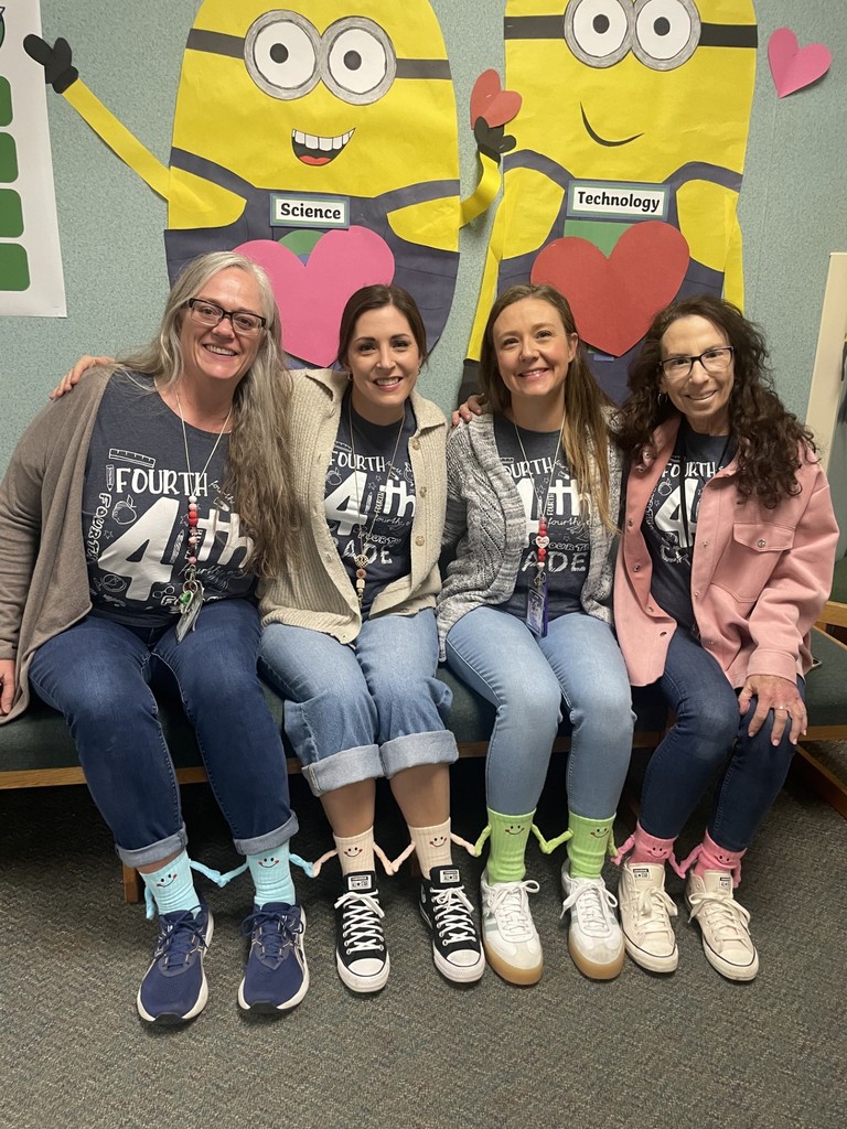 4th grader teachers pose with their friendship socks