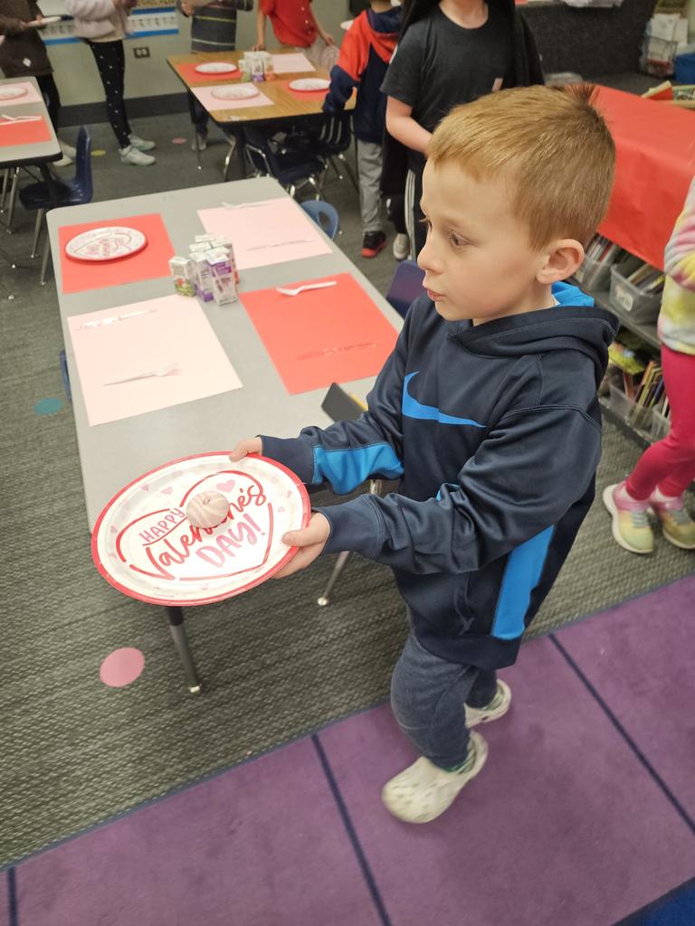 student holding a valentine plate