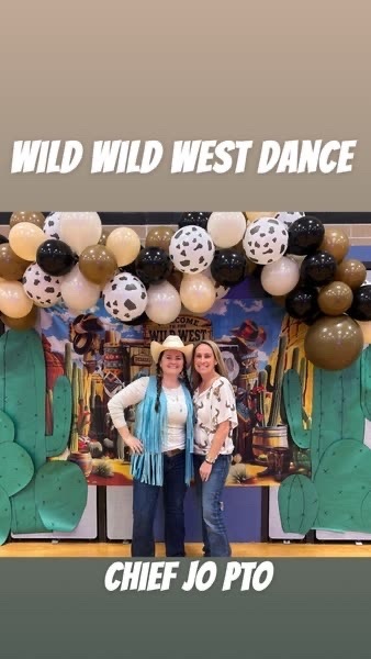 An image showing 2 PTO members at the photo op of the Wild West themed dance.