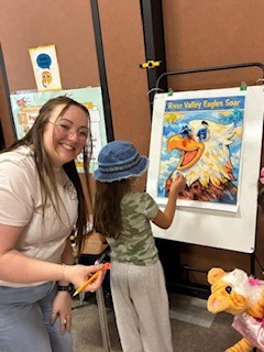 teacher and student in front of an easel 