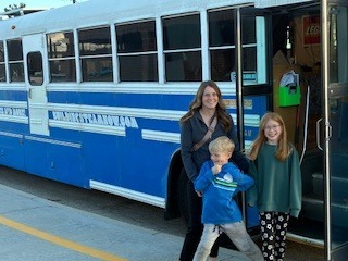 family in front of a bus