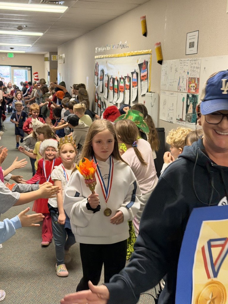 Top readers are in a school parade procession being cheered on by the student boyy