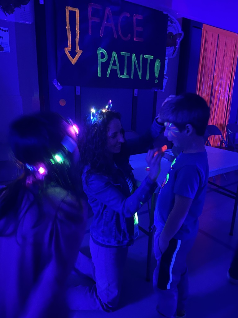 a kiddo getting his face painted by Mrs. Griffin