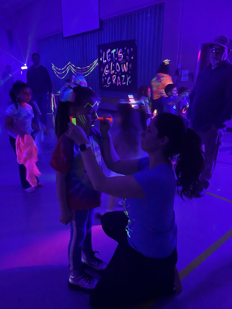 a kiddo get her face painted by Mrs. Medley