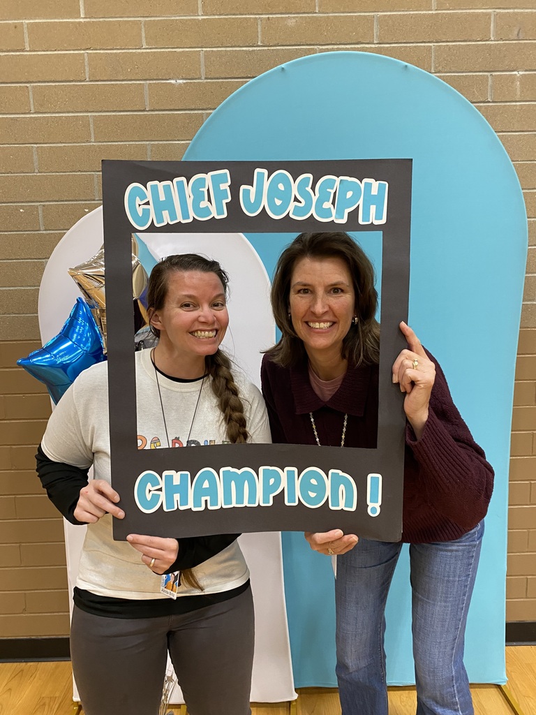 An image of 2 teachers holding a sign that says "Chief Joseph Champion!"