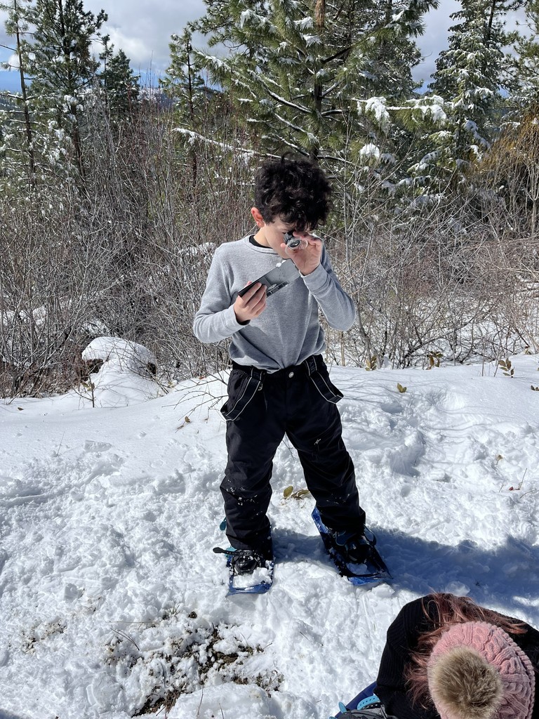 4th grader viewing snow flakes under a hand held magnifying glass