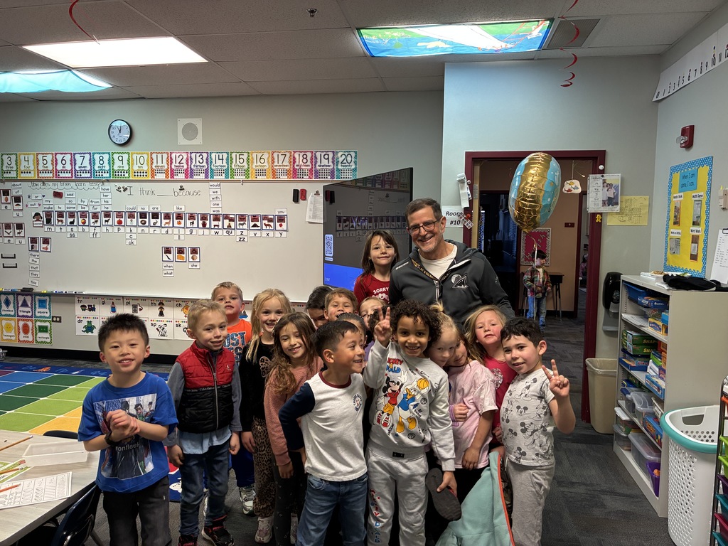 students in a classroom standing with the principal