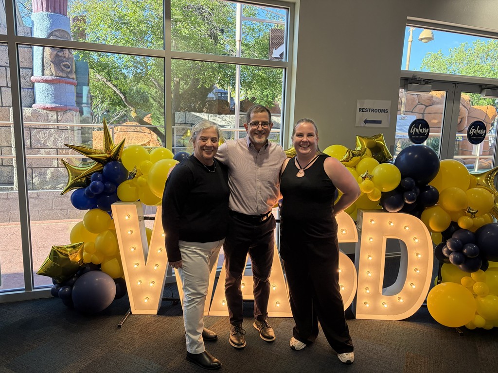 3 people in front of WASD sign 