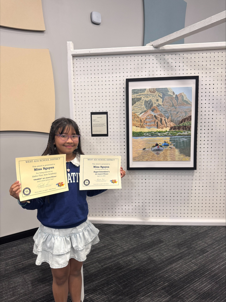 Student, Mina N, standing in front of her scenic art and holding two certificate awards.