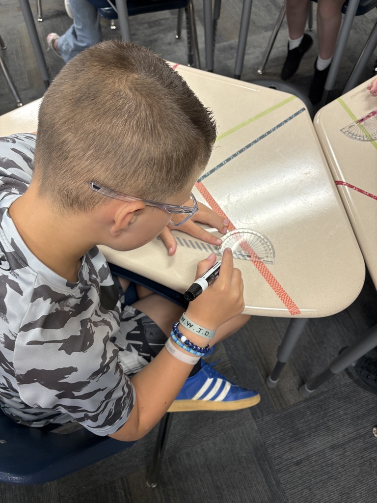 An image of a student measuring angles on a desk 