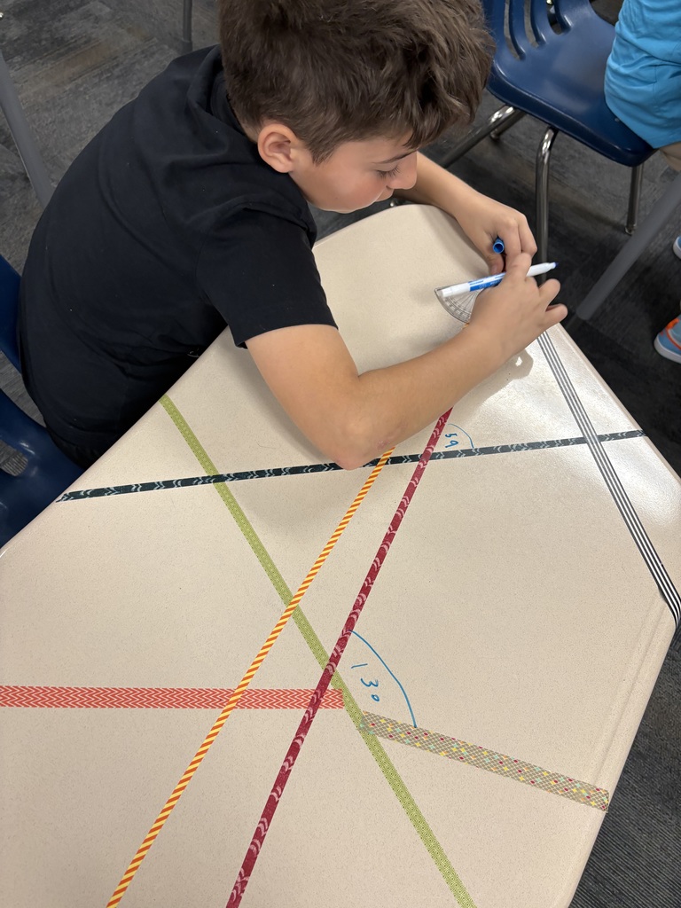 An image of a student measuring angles on a desk 