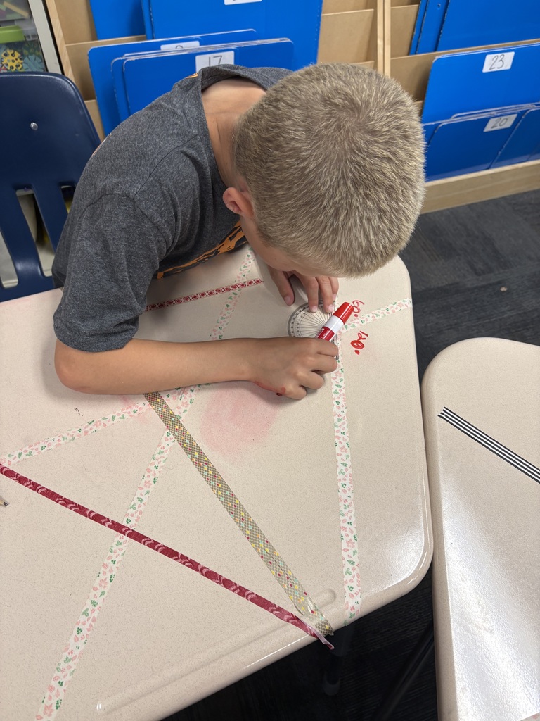 An image of a student measuring angles on a desk 