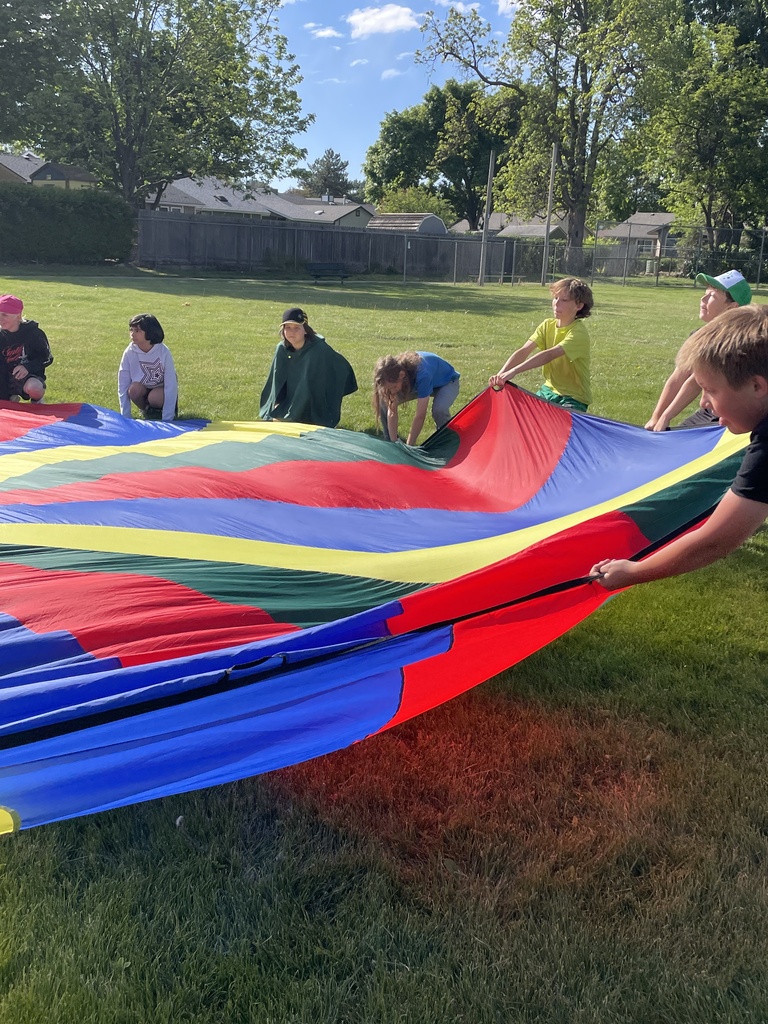 5th graders holding onto the parachute