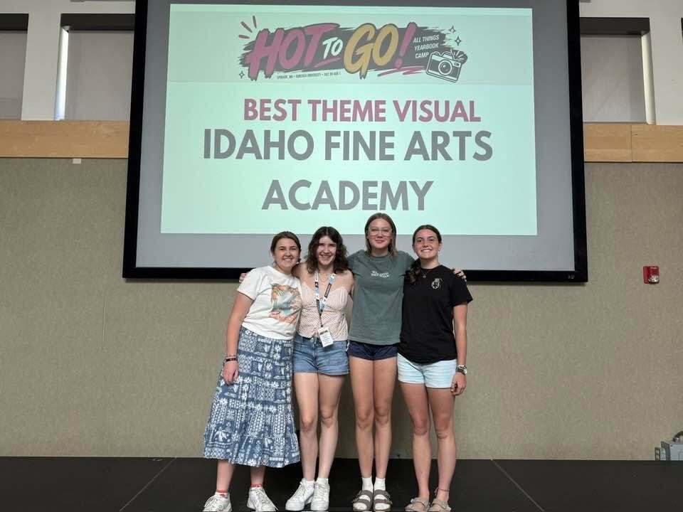 Four IFAA Yearbook editors stand in front of screen that says "Hot to Go! Best Theme Visual, Idaho Fine Arts Academy".