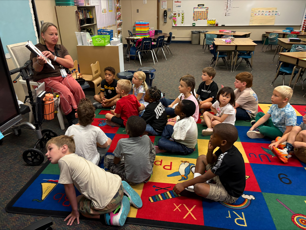Mrs. Dunlop reading a book to first graders.