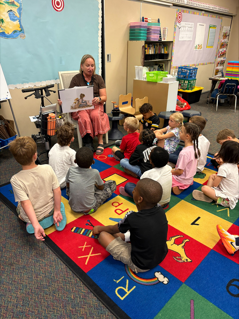Mrs. Dunlop reading a book to first graders.
