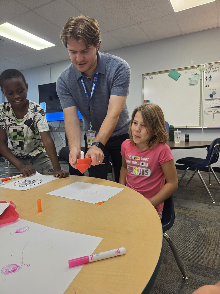 man helping kids do spinning marker art