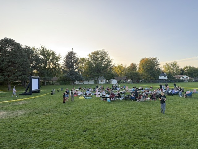 families gathered on field waiting for movie to start