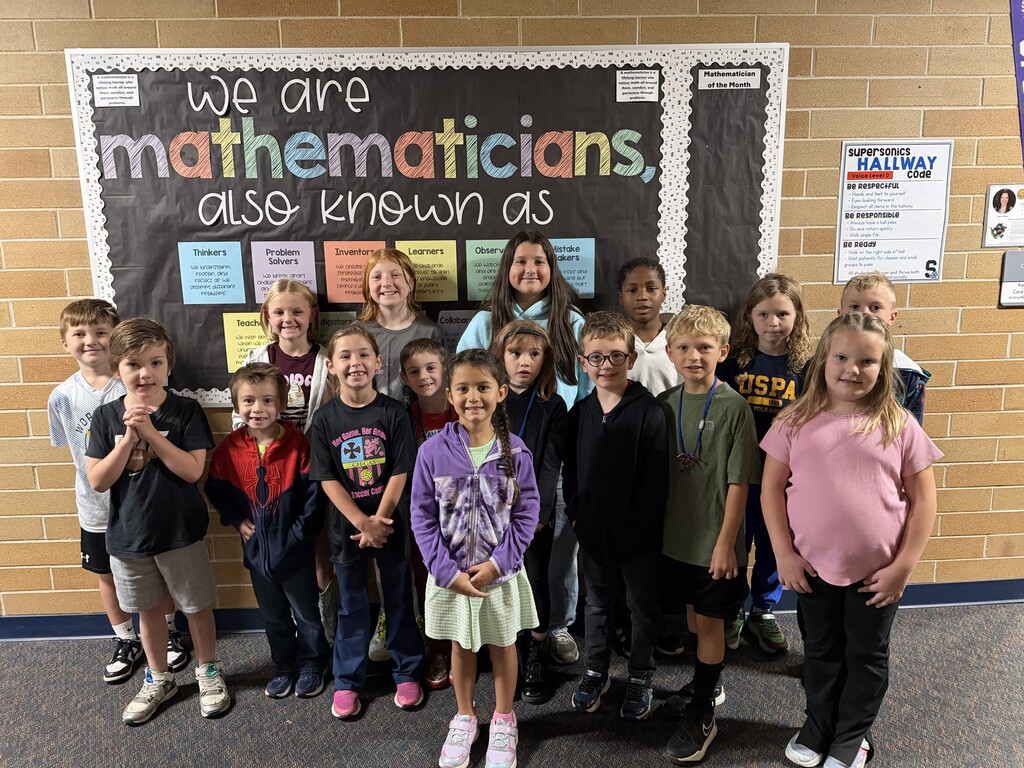 Students standing in front of a Mathematician Board