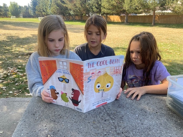 Kids reading outside.