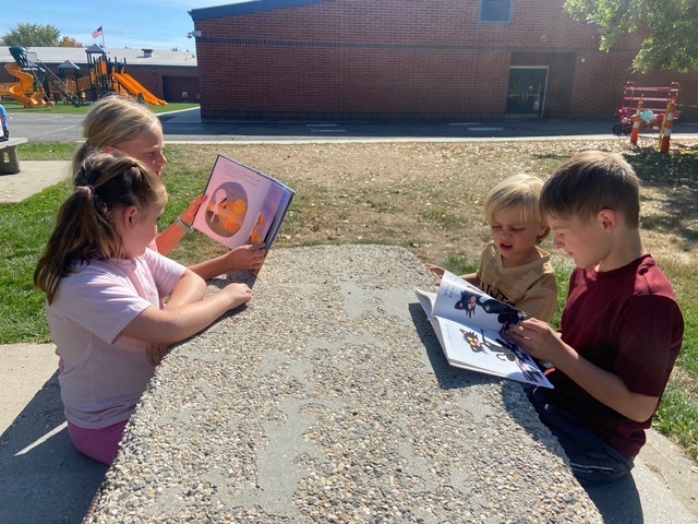 Kids reading outside.