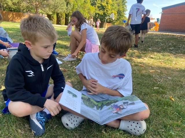 Kids reading outside.