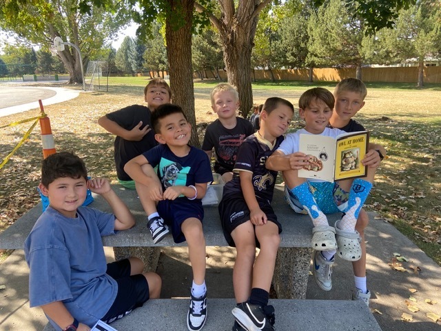 Kids reading outside.