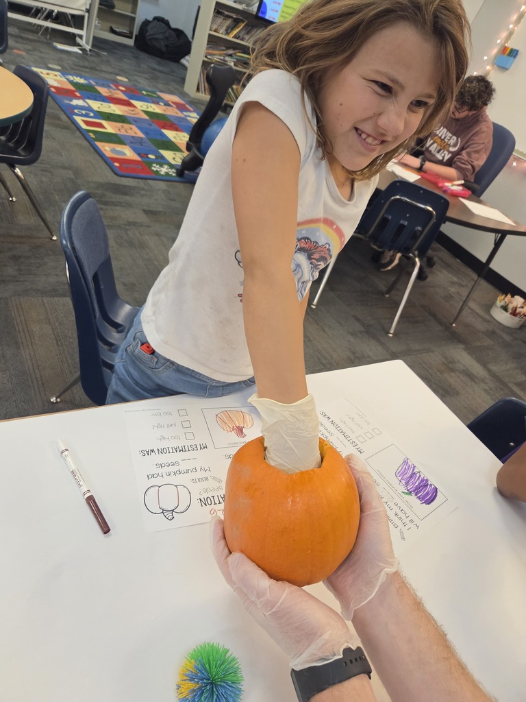 child with hand in pumpkin