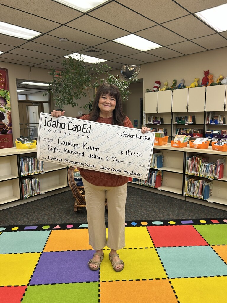 Mrs. Knam proudly holding her check from Idaho CapEd.