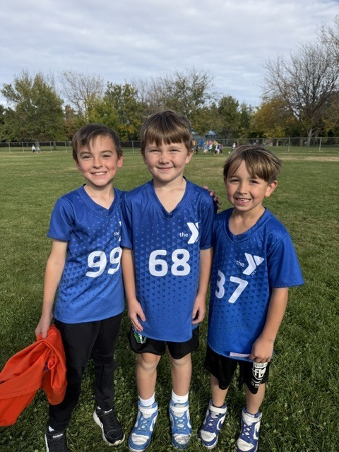 3 boys in matching black shorts and blue soccer jerseys
