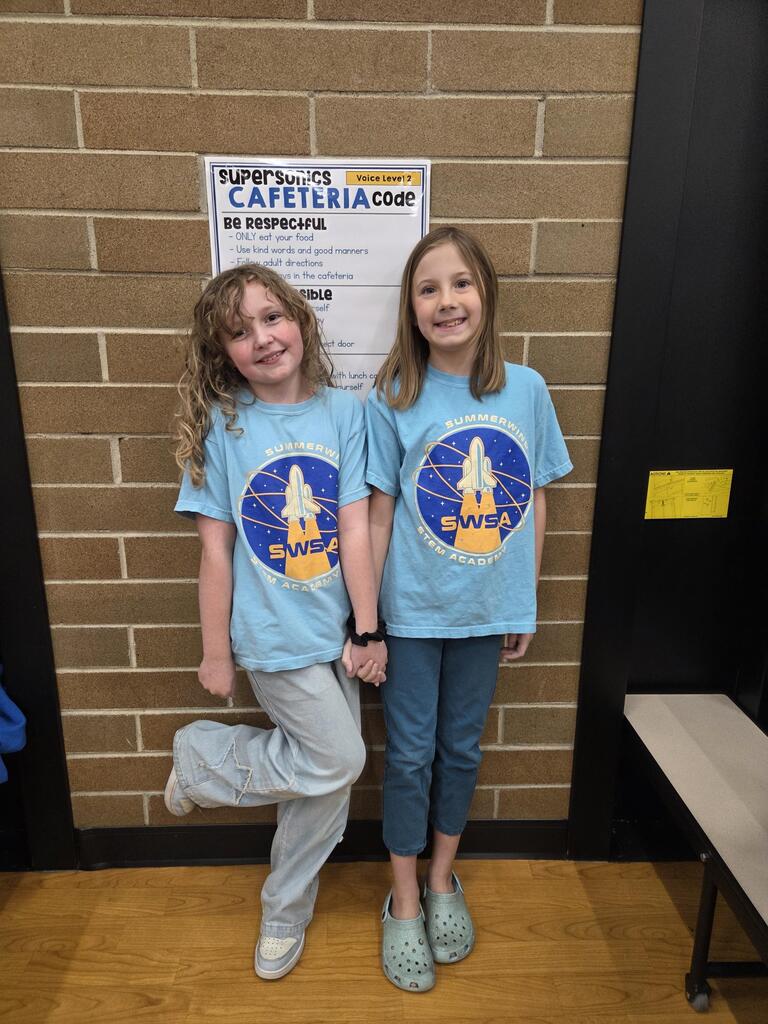 two girls in matching school shirts