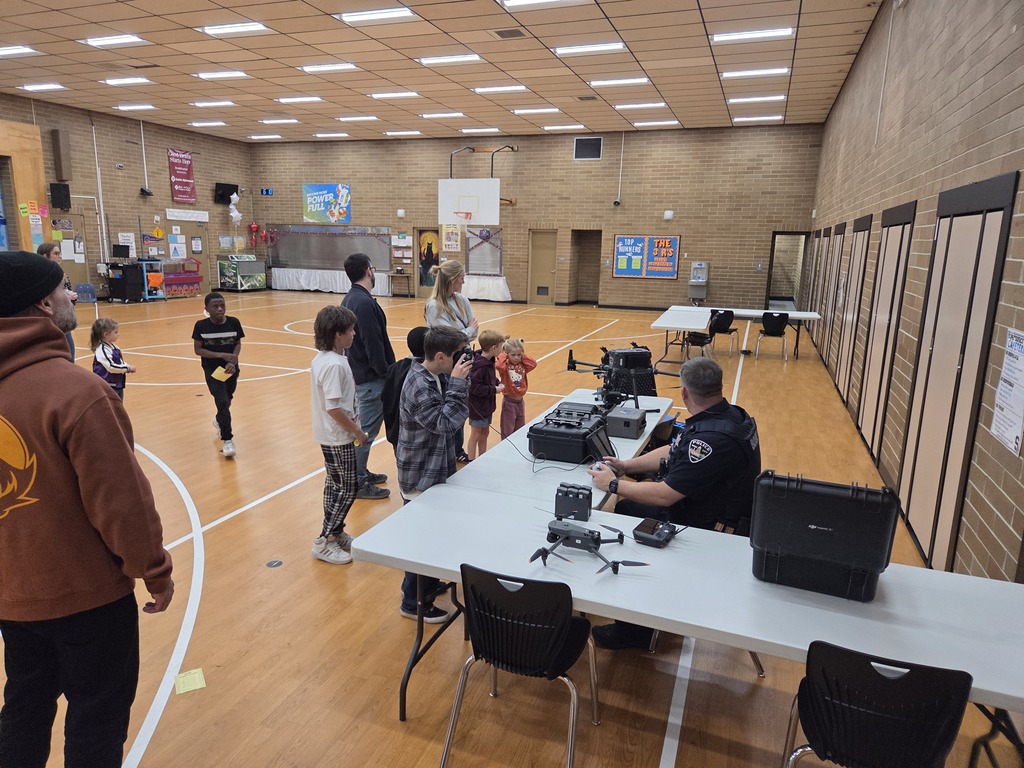 Officer flying a drone while kids watch