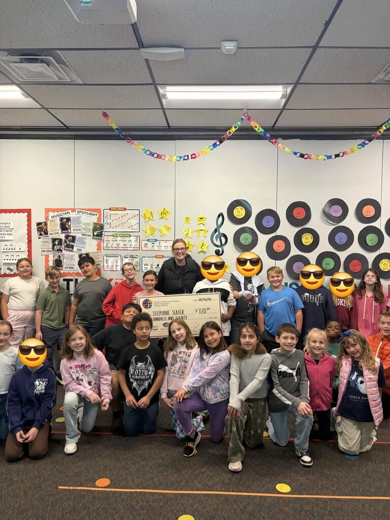 Music Teacher with students and Grant check