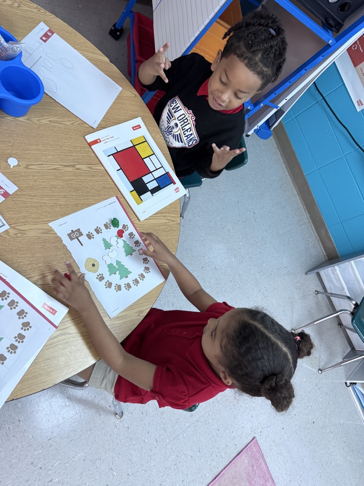 Ms. Kelli’s class using one-to-one correspondence by counting only the red beans and moving the bear to reach the honey. 