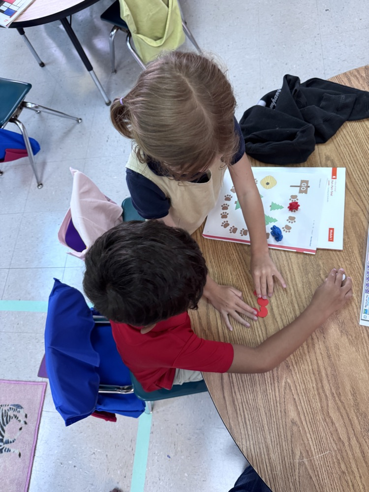 Ms. Kelli’s class using one-to-one correspondence by counting only the red beans and moving the bear to reach the honey