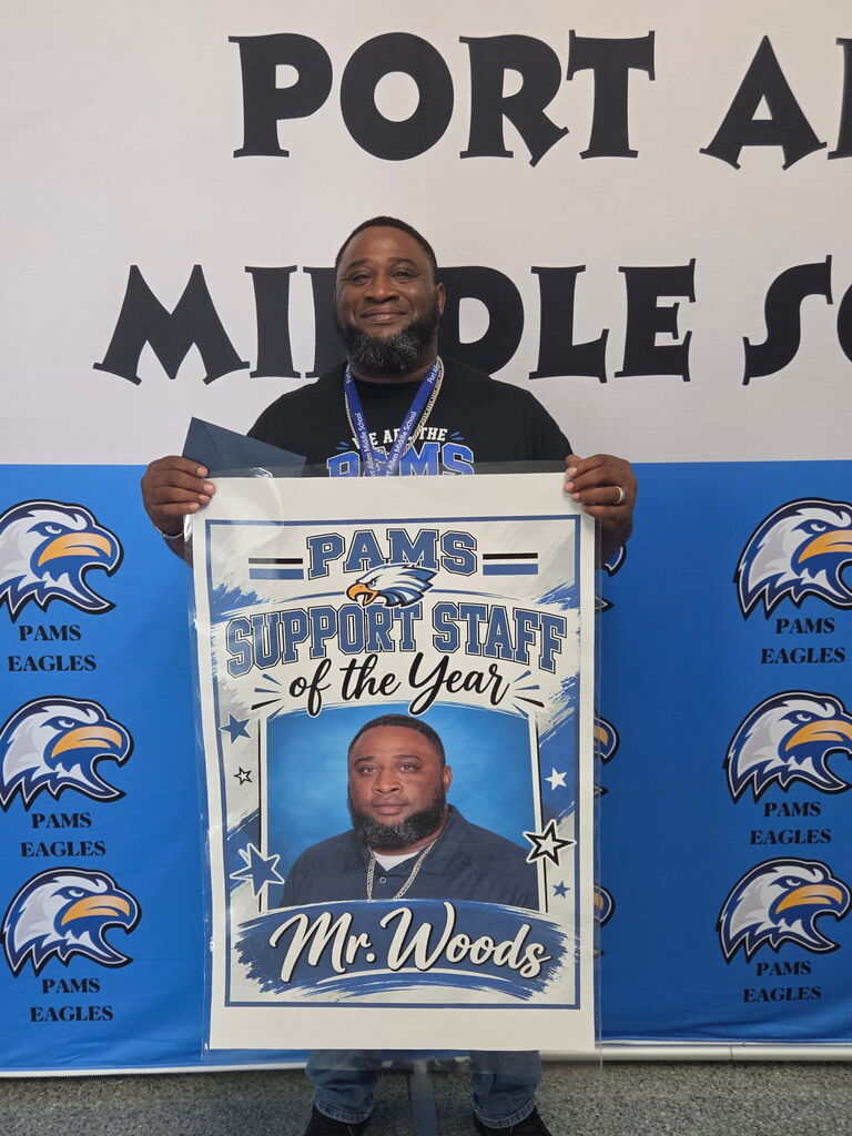 A man holds a certificate labeled "PAMS SUPPORT STAFF of the Year." The certificate features a photo of Mr. Woods.