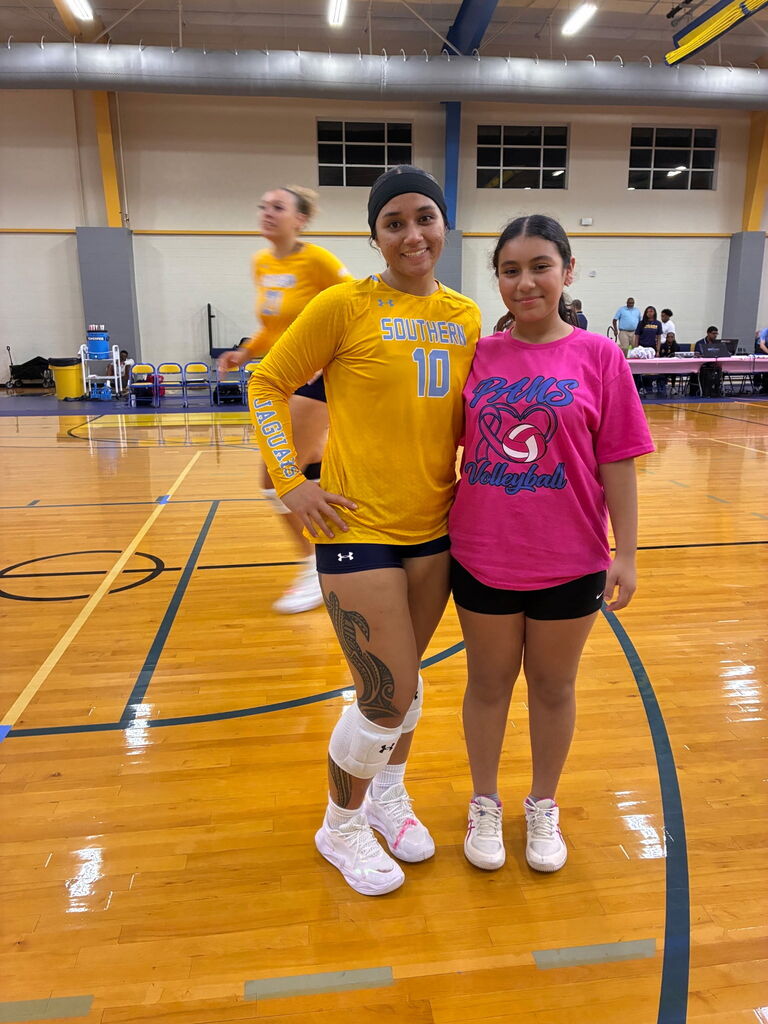 Two individuals in a gym, one wearing a yellow shirt with "SCOTTSDALE" and number 10, the other in a pink shirt.