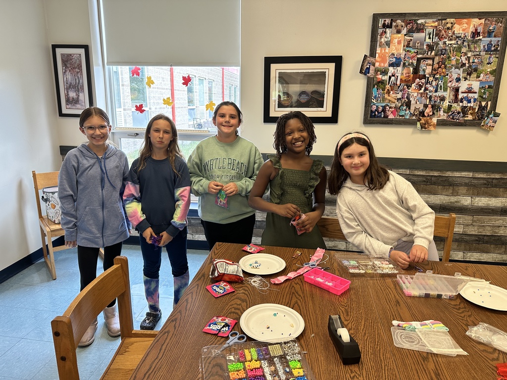 girls in front of a table full of beading supplies