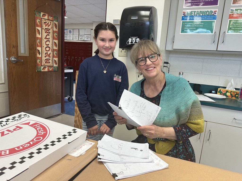 4th grade student showing her writing to visiting author Leslie Connor.