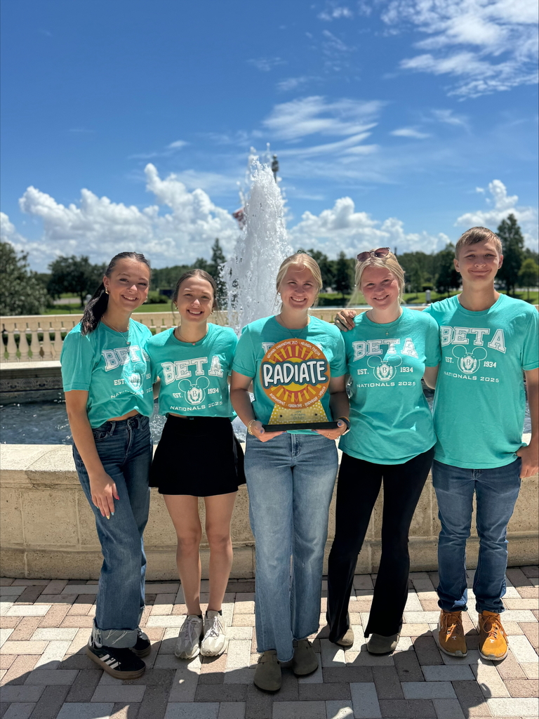 WCSSDS student with national beta trophy won during natiobnal competion, wearing beta shirt in front of a fountain