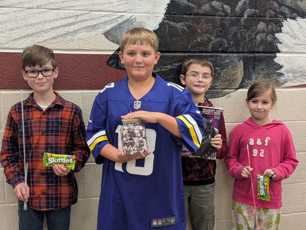 wces students participating in red ribbon week holding up prizes and dressed on special red ribbon days